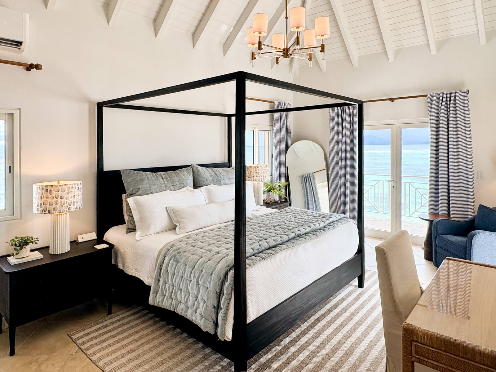 Villa Bénie interior — light-filled living room with linen sofas, natural stone, and ocean views